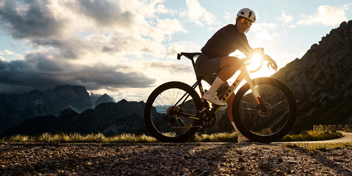 Cyclist on a Trek Domane in the mountains at sunset